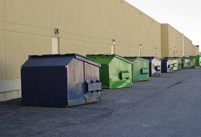 construction workers throw waste into a dumpster behind a building in Battle Ground, IN